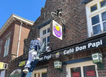 Schilder Patrick Metten voert houtrotreparatie uit aan een gevelkozijn in het centrum van Weert
